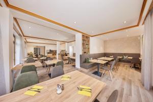 奥托博伊伦巴尔赫伽尼酒店的配有木桌和桌椅的餐厅