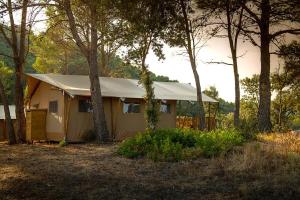 TerradesGlamping VALL de CODÓ的树林里一座黄色房子,有帐篷