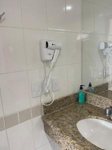 马瑙斯Flat Tropical的浴室配有盥洗盆和吹风机