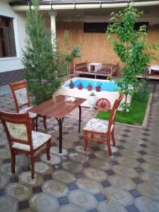 撒马尔罕SAMARKAND AMIRA的一个带桌椅的庭院和一个游泳池