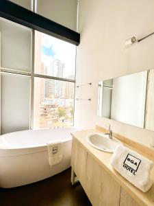 布卡拉曼加BGA酒店 的带浴缸、水槽和窗户的浴室