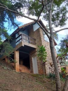 伊泰帕瓦Pousada Alto Itaipava的石头房子的一侧设有阳台