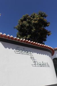 费雷拉杜阿连特茹SOLAR DOS FRADES的建筑的一边有树的标志
