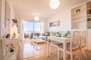 阿德耶Roque del Conde Seaview的用餐室以及带桌椅的起居室。