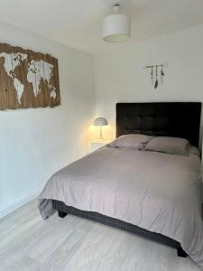 卢贝新城Havre de Paix的一间白色客房内配有一张大床的卧室