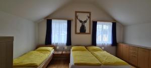 施特罗布尔Ferienhaus Pepi的一间卧室设有两张床和两个窗户。