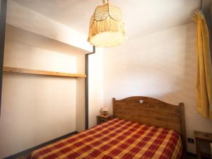 琴山朗勒堡Appartement Lanslebourg-Mont-Cenis, 2 pièces, 4 personnes - FR-1-508-71的一间卧室配有一张床和一个吊灯