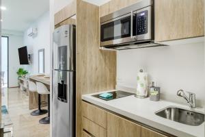 普拉亚卡门The Perfect Place, Unit 005的厨房配有不锈钢冰箱和水槽