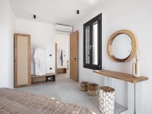 阿达玛斯Athina Milos Suites的一间带镜子的卧室和更衣室