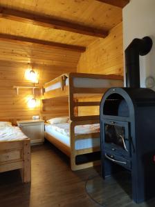 Srednja Vas v BohinjuApartma Hodnik Uskovnica的客房设有两张双层床和燃木炉。