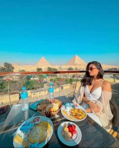 开罗Sahara Pyramids Inn的坐在餐桌上吃盘子的女人
