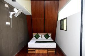 瓦亚纳德Misty Ghats Resort的一间小卧室,卧室内配有一张床铺