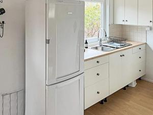 南泰利耶Holiday home Södertälje的白色的厨房配有冰箱和水槽