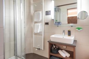 拉布拉Vitalpina Hotel Waldhof的一间带水槽和淋浴的浴室