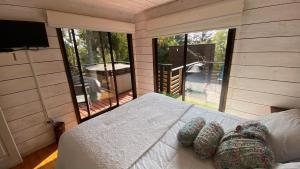 皮奇勒姆Cabaña del Bosque的一间卧室设有一张床和一个大窗户