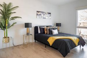 夏洛特Luxurious & Comfy Downtown Oasis ~ Views ~ Parking的一间卧室配有一张床和盆栽植物