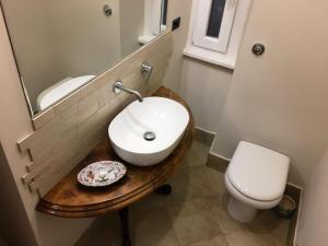 罗马Foscari Holiday House的一间带水槽、卫生间和镜子的浴室