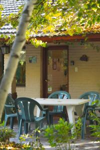 特雷利乌蜂鸟自然小屋住宿加早餐旅馆的房子前面的一张桌子和椅子