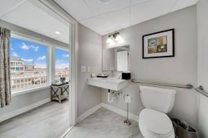 五月岬郡蒙特利尔海滩度假酒店的一间带卫生间、水槽和窗户的浴室