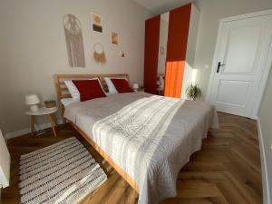 加茨比亚格拉Przystanek Jastrzebia的一间卧室配有一张带红色枕头的大床