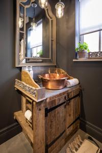 南特威奇Cheshire Boutique Bathhouse的一间带铜制水槽和镜子的浴室