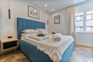 斯普利特West Coast Deluxe Rooms - Vacation Rental的卧室里一张带蓝色床头板的床
