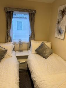 新罗姆尼Beautiful Spacious Holiday Home - Romney Sands的小型客房 - 带2张床和窗户