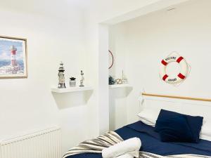 朴次茅斯Seafront Apartment的一间白色卧室,配有一张床和一个红色灯塔
