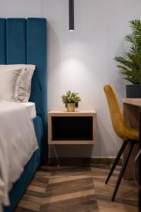 斯普利特West Coast Deluxe Rooms - Vacation Rental的一间卧室配有一张床和一张桌子,上面有植物