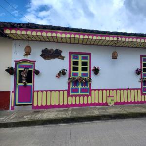 菲兰迪亚Hostal Casa Madrigal的色彩缤纷的房屋,设有色彩缤纷的大门和栅栏