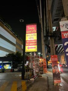 曼谷Mall Suites Hotel的夜间街道边的标志
