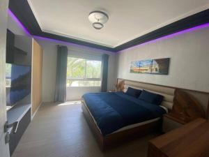 阿加迪尔Marina Agadir - Luxury Pool view apartment 2Bdr的一间卧室配有蓝色的床和紫色照明