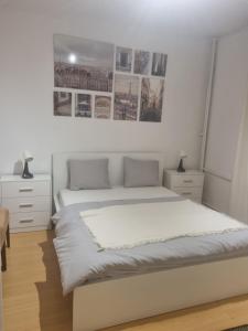 华沙Old Town Pearl的卧室配有一张白色大床,墙上挂有图片