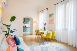 佛罗伦萨Condotta 16 Apartments的客厅配有沙发和带黄椅的桌子