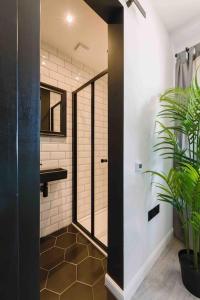格拉斯哥ComfySleep ApartHOUSE的带淋浴、盥洗盆和镜子的浴室