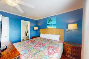 格尔夫海岸Abaco House的蓝色的卧室设有床和木桌