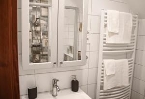 大毛罗什Dunna Vendégház的浴室配有盥洗盆、镜子和毛巾