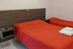 圣地亚哥-德尔埃斯特罗Premier的一间卧室配有两张红色床单