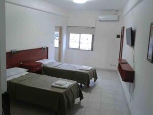 圣地亚哥-德尔埃斯特罗Premier的酒店客房设有两张床和电视。