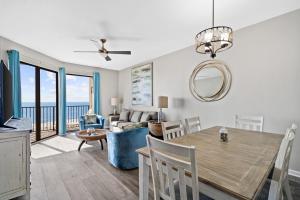 奥兰治比奇Phoenix VII 71113 by ALBVR - Beautiful Beachfront Condo with Amazing Views & Amenities!的用餐室以及带桌椅的起居室。