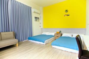 Chaozhou上海民宿的一间卧室设有两张床和黄色的墙壁