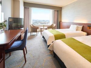 北九州Rihga Royal Hotel Kokura Fukuoka的酒店客房配有两张床和一张书桌