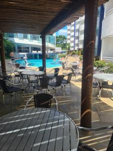 热河市Rio Quente Aguas da Serra Apart的一个带桌椅的户外庭院和一个游泳池