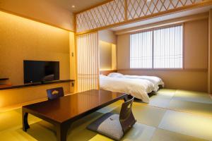 京都本能寺酒店的一间卧室配有一张床、一张桌子和一台电视。