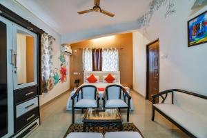 瓦斯科达伽马Dewa Goa Hotel Near Dabolim Airport的配有床和两把椅子及一张桌子的房间