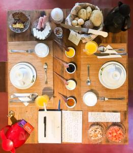 圣安娜杜里亚舒Pousada Villa Madorna的桌子上摆着盘子和餐具,上面摆着食物