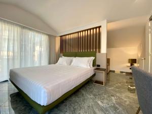 切法卢Salemare Rooms & Suites的卧室设有一张白色大床和一扇窗户。