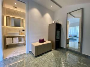切法卢Salemare Rooms & Suites的浴室设有镜子、凳子和水槽