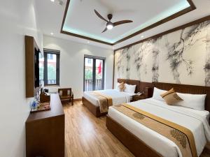下龙湾Samatha Hotel Bai Chay, Ha Long的酒店客房配有两张床和吊扇。