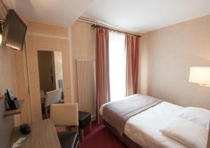 巴黎肯辛顿埃菲尔酒店的配有一张床、一张书桌和一扇窗户的酒店客房